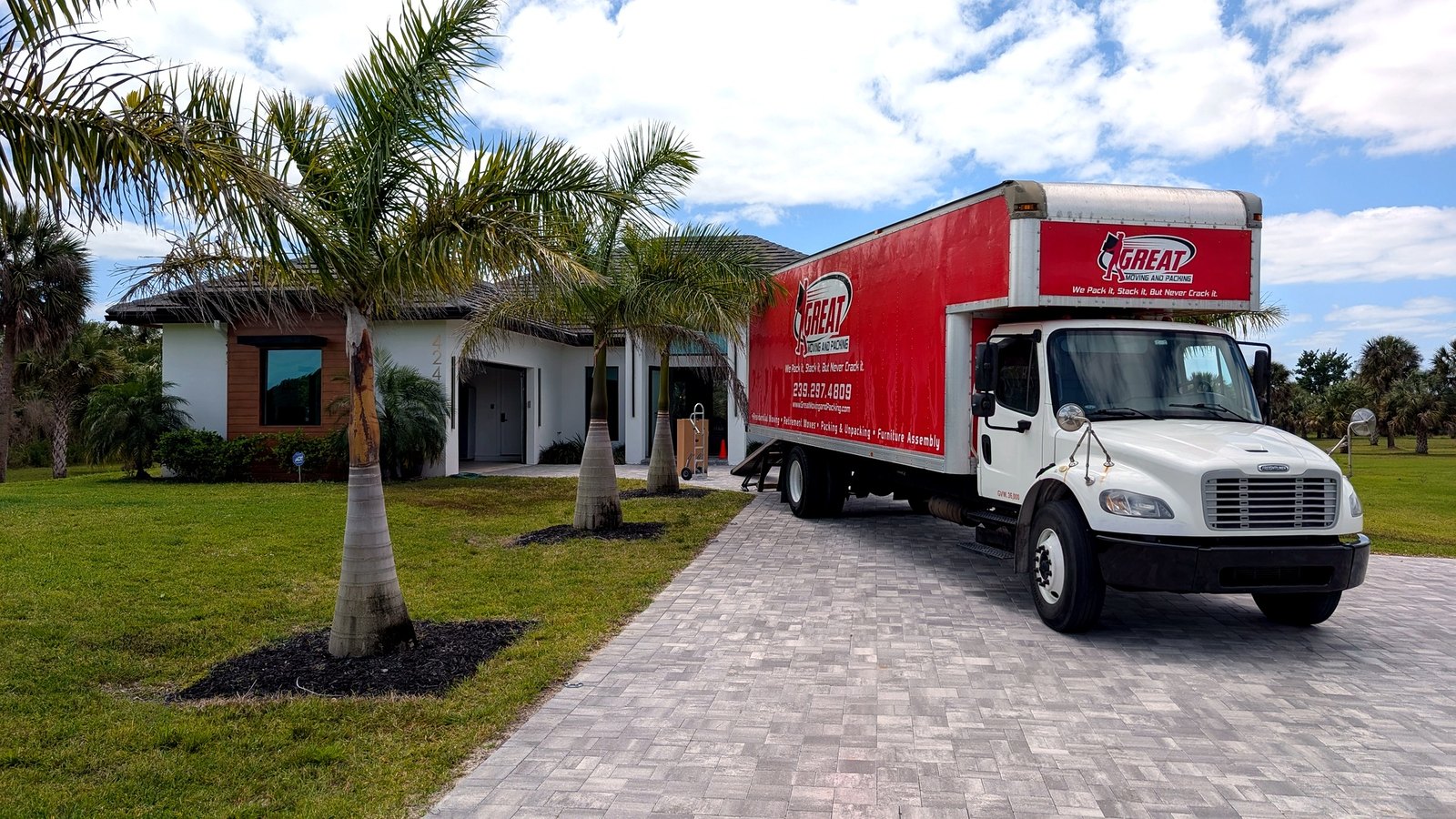 Great Moving & Packing truck on a Southwest Florida residential street — licensed local movers, (239) 297-4809