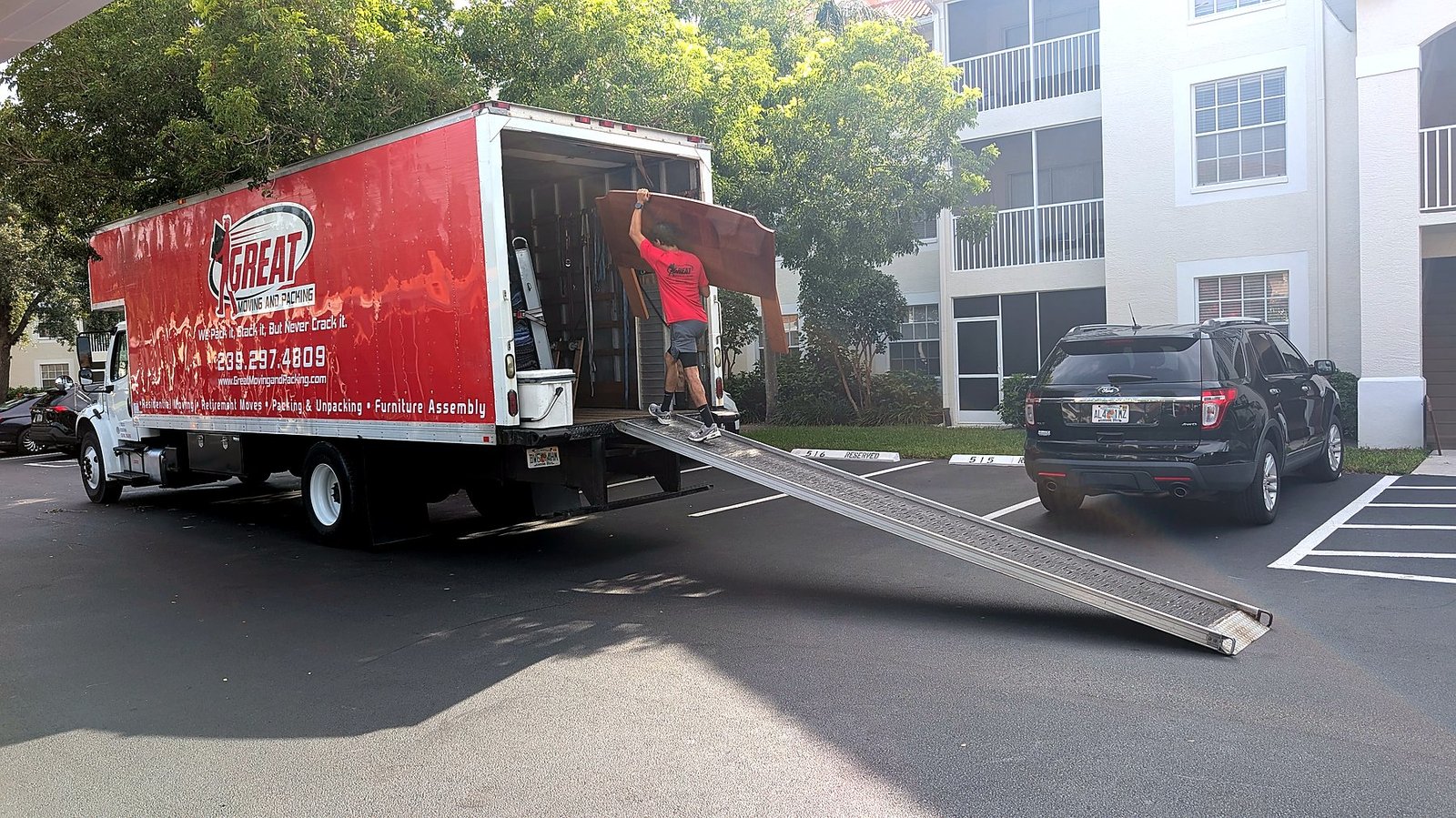 Great Moving & Packing truck and crew loading at a Southwest Florida multi-family building — condo and apartment move specialists
